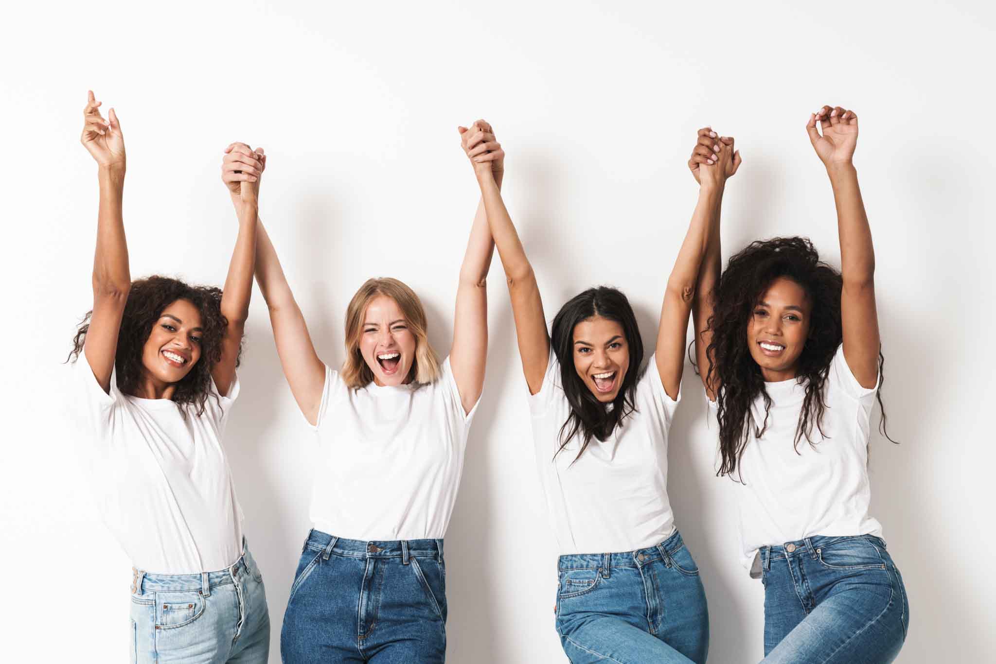 Image of a pretty happy young women multiracial friends posing isolated over white wall background with raised hands.
